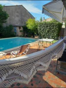 una piscina con sillas, una mesa y una sombrilla en Maison Du Soleil Quiet And Central, en Les Angles