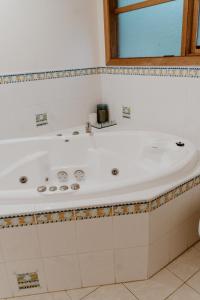 baño con bañera blanca y ventana en The Cherry Blossom Suite, en The Patch