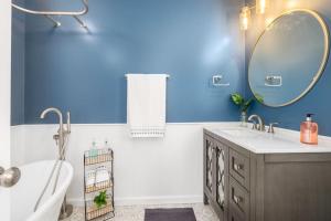 ein Badezimmer mit blauen Wänden, einer Badewanne und einem Waschbecken in der Unterkunft Relaxing 2-Master Suite Mountain Top - Fire Pit in New Market