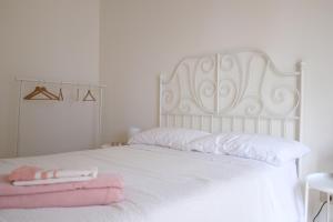 a white bed with white sheets and pink towels on it at Casa Boccaccio 7 in Pescara