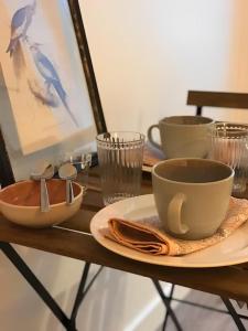 una mesa con platos y tazas y una taza de café en Nice T1 in the Clermont Historical Centre en Clermont-Ferrand