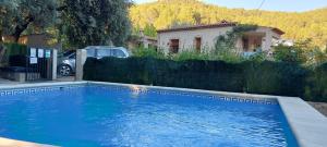 a blue swimming pool in front of a house at Casas rurales amable- yeste in Cortijo Prados