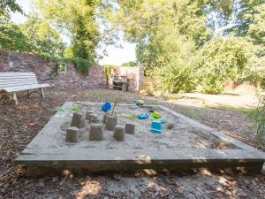 a sandcastle in a yard with a bench and trees at Ferienwohnung Fresenhuus 3, FeWo Vermittlung Nordsee in Dangast
