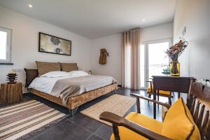 a bedroom with a bed and a desk and a window at Advania Country House in Lourinhã +74 photos