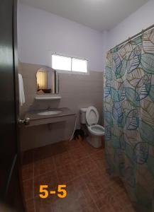 La salle de bains est pourvue de toilettes, d'un lavabo et d'un miroir. dans l'établissement Bansuanrachawadee B&b, à Si Saket