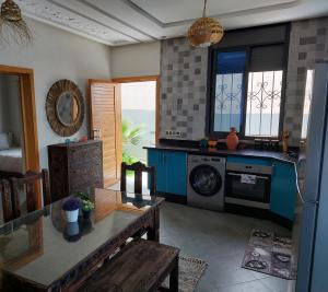 a kitchen with a washing machine and a table at Magnifique villa face à l'océan in Tiznit