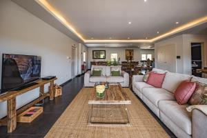 a living room with a couch and a tv at Advania Country House in Lourinhã