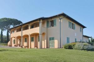 a large building with green shutters on a grass field at Appartamenti Casalsole in Cerreto Guidi