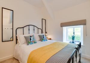 sypialnia z dużym łóżkiem i oknem w obiekcie Court Cottage w mieście Berrynarbor