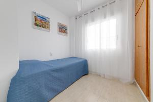Un dormitorio con una cama azul y una ventana en Casa Godisa, en Torrevieja