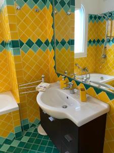 a yellow bathroom with a sink and a mirror at APPARTAMENTO VISTA MARE CASTELSARDO in Castelsardo