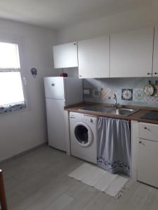 a kitchen with a sink and a washing machine at Appartamento Cavo in Cavo +7 photos