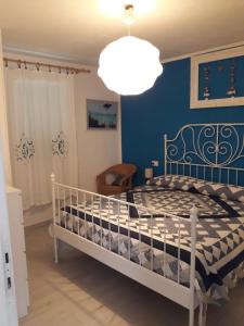 1 dormitorio con 1 cama con pared azul en Appartamento Cavo, en Cavo