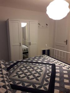 a bedroom with a bed with a black and white quilt at Appartamento Cavo in Cavo