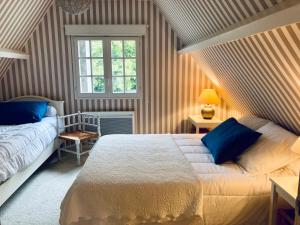 1 Schlafzimmer mit 2 Betten und einem Fenster in der Unterkunft Les Forrières Maison de Campagne in Thil-Manneville
