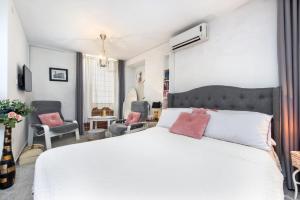 um quarto com uma cama branca e 2 cadeiras em Apartments Casa Ivona em Rovinj