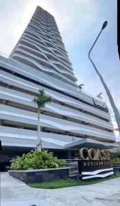 un grand bâtiment avec un palmier en face dans l'établissement Coast Residence 4026 PENTHOUSE 1 Bedroom Condo with Wifi & Netflix, à Manille
