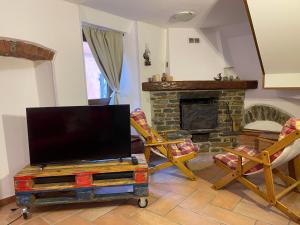 a living room with a tv and a fireplace at New Ca de na volta - tra Liguria e Toscana in Albiano