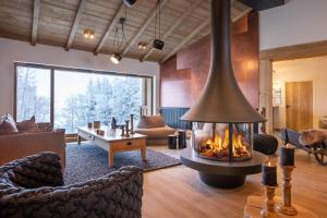 a living room with a fireplace in the middle at Snoroc by Daddy Pool- TERRESENS in Aime La Plagne