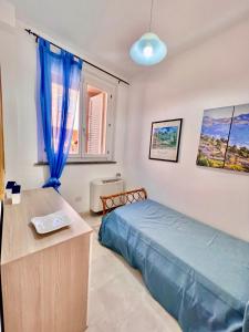 a bedroom with a blue bed and a window at Appartamento Bell’Umore in Castiglione della Pescaia +43 photos