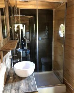 a bathroom with a glass shower and a white bowl at Camping de Rouergue in Villefranche-de-Rouergue