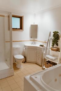 a bathroom with a toilet and a sink and a tub at The Garden Suite in The Patch