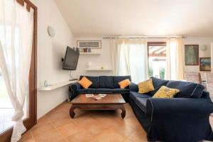 salon z niebieską kanapą i stołem w obiekcie Villa Babajola - 500m from the beach w mieście Costa Rei