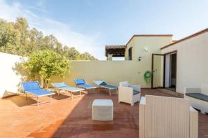 patio z niebiesko-białymi krzesłami i ścianą w obiekcie Villa Babajola - 500m from the beach w mieście Costa Rei