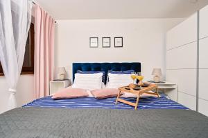 1 dormitorio con 1 cama azul y 2 copas de vino en Liori apartment, en Rubeši