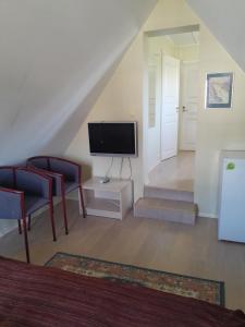 a living room with a tv and chairs and a staircase at Inge Villa in Pärnu