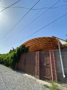 a garage with a wooden gate and a brick building at Hostel 4U in Bishkek