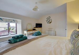a bedroom with a large bed with two pillows on it at Cross Farm Cottage in Braunton