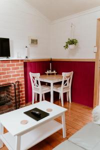 ein Wohnzimmer mit einem Tisch und einem Kamin in der Unterkunft The Mulberry Cottage in The Patch