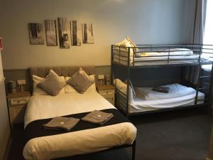 a room with two beds and a bunk bed at Queens Guesthouse Manchester in Manchester