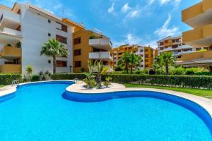 a swimming pool in front of a building at Amazing - La Recoletta 2 Bed apt - 2 Pools in Punta Prima