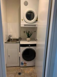 a small kitchen with a microwave and a sink at Plush @ Benjamin way Belconnen in Belconnen