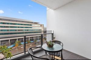 a balcony with a table and chairs and a building at Plush @ Benjamin way Belconnen in Belconnen