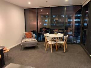 a room with a table and chairs and a couch at Plush @ Benjamin way Belconnen in Belconnen