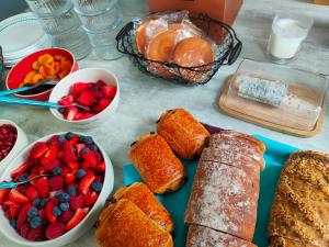 einen Tisch mit Gebäck, Obst und anderen Lebensmitteln in der Unterkunft Bienvenue chez moi à Concevreux in Concevreux
