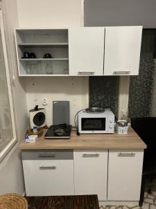 a kitchen with white cabinets and a microwave on a counter at Irina Apartments in Piteşti