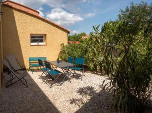a patio with a table and chairs next to a building at Entre Monts et Vermeille in Sorède