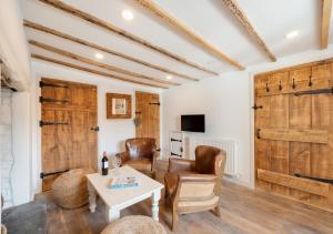- un salon avec des portes en bois, une table et des chaises dans l'établissement Croyde Farm Cottage, à Croyde