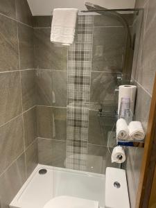 a bathroom with a shower and a toilet and towels at Garden Rooms in Pitlochry