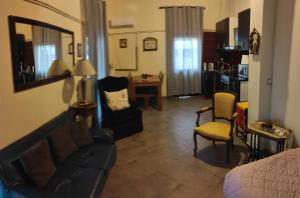 Near AirportAnd metropolitan Penelopi Cozy Home في أرتيميدا: غرفة معيشة مع أريكة وكرسي