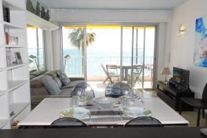 a living room with a table and a view of the ocean at Splendid T2 "San Remo" waterfront air-conditioned and with parking in Juan-les-Pins