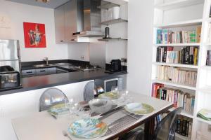 a kitchen with a table with plates and glasses at Splendid T2 "San Remo" waterfront air-conditioned and with parking in Juan-les-Pins
