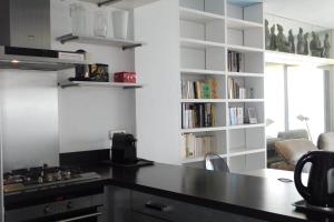 a kitchen with a black counter and a book shelf at Splendid T2 "San Remo" waterfront air-conditioned and with parking in Juan-les-Pins