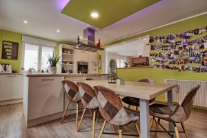 cocina con mesa de madera y sillas en Aux grains de raisin - 6 personnes - cour privée en Scherwiller