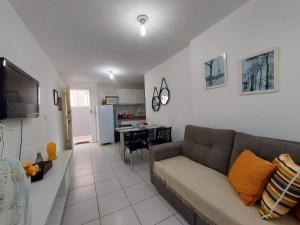 a living room with a couch and a kitchen at Apto. 1 dormitório no M. de Nassau - Ed. Manhattan Home Service 302 in Caruaru