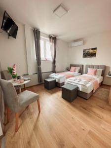 sypialnia z 2 łóżkami, stołem i krzesłem w obiekcie San Lux Dunavska w Nowym Sadzie